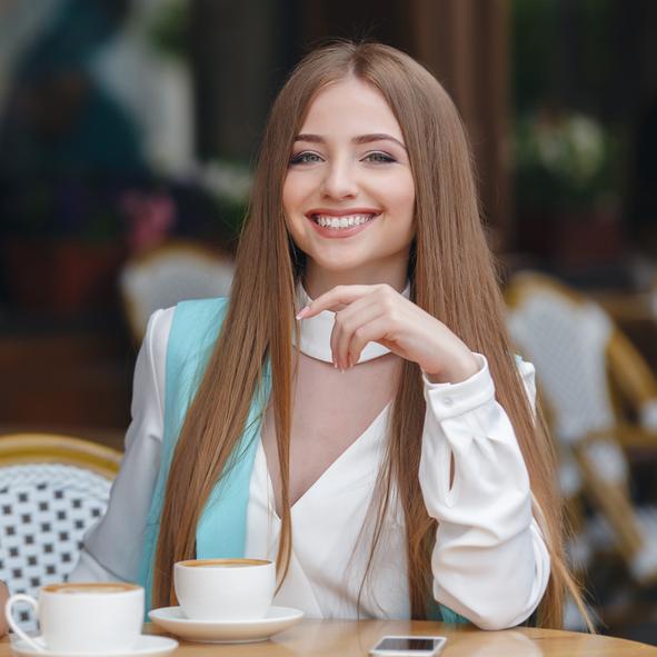 A woman holding a jar of cream in front of her face.