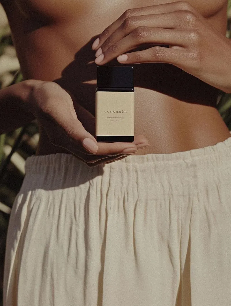 A woman holding a bottle of perfume in her hand.